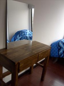 拉巴斯A Place in the Sky - c23 Calacoto的一张木桌,床边设有镜子