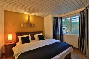 努沃勒埃利耶勒马度假屋的一间卧室设有一张大床和一个窗户。