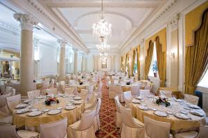 毕尔巴鄂卡尔顿酒店的宴会厅配有桌椅和吊灯