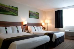 斯劳假日斯劳温莎酒店度假村的酒店客房设有两张床和窗户。