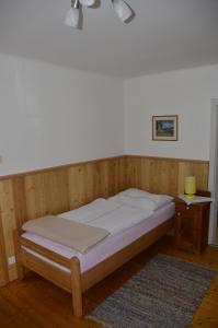 阿德蒙特Haus Rosina的木间内的一张床位,配有床头柜和一张四柱床