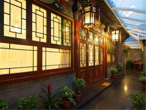 北京北京荣府老宅四合院精品酒店 的一座建筑,有一堆窗户和植物
