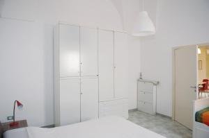 奥斯图尼Micca House的白色卧室配有白色橱柜和1张床