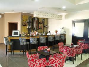 Anchialos克里尼奥斯宫殿酒店的一间设有红白椅子的餐厅和一间酒吧