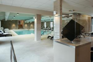 摩拉瓦托普利采特马尔酒店 - 温泉3000 - 萨瓦酒店及度假村的大堂设有游泳池,玻璃盒里设有电视