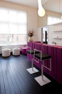安特卫普B&B Suites FEEK的厨房配有带凳子的紫色柜台