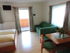 安泰塞尔瓦·迪·梅佐库莱霍夫公寓的客厅配有绿色沙发和桌子