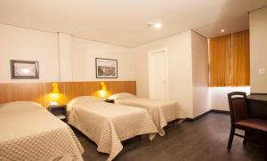 圣保罗格兰德巴朗酒店的带2张桌子的房间的两张床