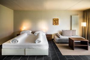 梅拉诺Villa Sasso的酒店客房设有一张大床和一张沙发。