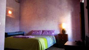 La NavaCasa Rural del Rio的一间卧室配有一张紫色的床和一张桌子