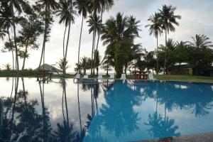 京那律兰卡莎巴斯海滩度假村的一座棕榈树环绕的大型游泳池