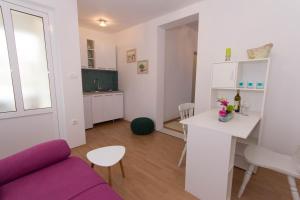 默主歌耶Apartments Kruno的客厅配有紫色沙发和桌子