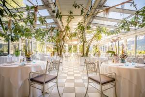 梅拉诺Villa Sasso的宴会厅配有桌椅和植物
