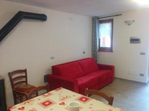 雷梅斯-诺特雷-达梅Les Racines的客厅配有红色的沙发和桌子