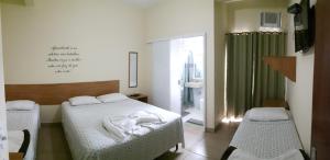 沃尔塔雷东达Pousada Casagrande - Roma的一间卧室设有两张床和绿帘