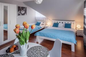 奥古斯图Villa Marta的一间卧室设有两张床和一张花瓶桌子。