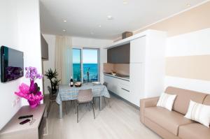米萨诺阿德里亚蒂科Lungomare Relax Residence的厨房以及带桌子和沙发的客厅。