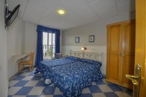 里瓦德奥利纳雷斯旅舍的一间卧室配有一张床、一张桌子和一个窗户。