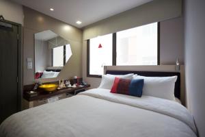 新加坡Hotel Clover 7的卧室配有一张白色大床和镜子