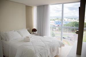 帕尔马斯精选酒店的配有大窗户的客房内的白色床