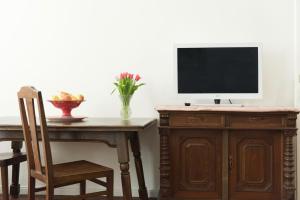 维也纳奥德维也纳公寓的一张桌子、一台电视和一张木桌及椅子