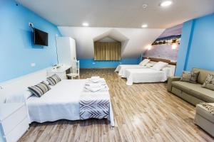 穆希亚Albergue Arribada的卧室拥有蓝色的墙壁,配有一张床和一张沙发