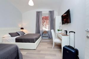 罗马圣彼得梵蒂冈公寓的一间卧室配有一张床和一张带行李箱的桌子