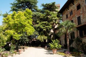 卢奇尼亚诺Residenza d'Epoca Il Cassero的一座种植了树木和植物的建筑前的花园