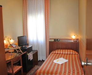 皮亚韦河畔诺文塔艾尔伯格里昂多罗餐厅酒店的酒店客房配有一张床、一张书桌和一台电视。
