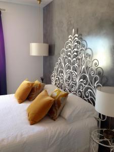 卡武埃鲁维温达布里托酒店的一间卧室配有白色床和黄色枕头