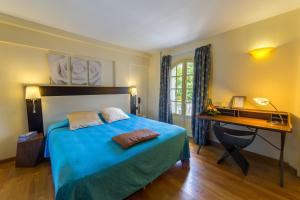 圣丹尼斯乐朱丽叶道杜酒店的一间卧室配有蓝色的床和一张书桌