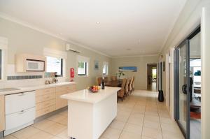 赫斯基森CeeSpray - Accommodation in Huskisson - Jervis Bay的一间厨房,配有白色橱柜和一间餐厅