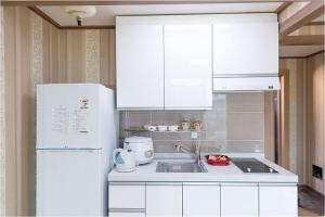 丽水市卡乐博卡度假屋的厨房配有白色橱柜和白色冰箱。