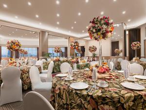 马尼拉金佰利马尼拉酒店的宴会厅配有长桌和白色椅子