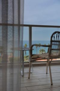 内坦亚David Tower Hotel Netanya by Prima Hotels - 16 Plus的阳台配有桌椅,享有海景