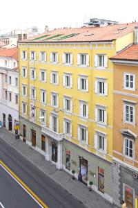 的里雅斯特罗马酒店的街道边的黄色建筑