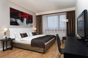 斯图加特斯图加特机场展览中心温德姆酒店的配有一张床和一台平面电视的酒店客房