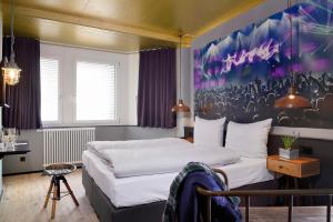 曼海姆Staytion Urban City Hotel Mannheim的卧室配有一张床,墙上挂有绘画作品