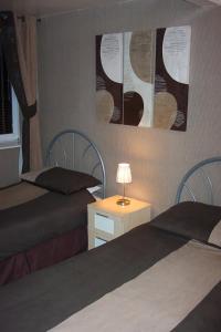 惠特利湾Melrose Guest House的一间卧室配有两张床和一张带台灯的桌子