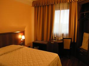 帕尔马达都国际酒店的配有一张床、一张书桌和一扇窗户的酒店客房