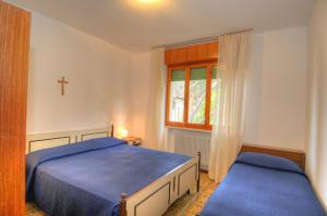 利尼亚诺萨比亚多罗Residence Villa Laura的卧室配有两张床,墙上有一个十字架