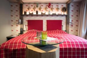 库夫施泰因Boutique Hotel im Auracher Löchl的一间卧室配有一张红色的床和玻璃桌