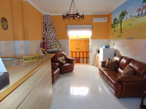 蓬蒂-迪索尔Residencial as Canárias的一间带真皮沙发的客厅和一间厨房