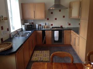 凯尔索Abbey View的厨房配有木制橱柜、水槽和炉灶。