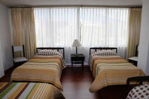 基多12月6日酒店的酒店客房设有两张床和窗户。