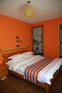 夏河县德吉园酒店的一间卧室拥有橙色的墙壁和一张大床