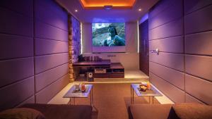 曾蒙海滩海因别墅的一间拥有紫色墙壁的客房,墙上配有电视