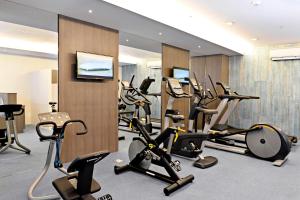 宿务Bayfront Hotel Cebu North Reclamation的健身房,配有一系列健身自行车和跑步机