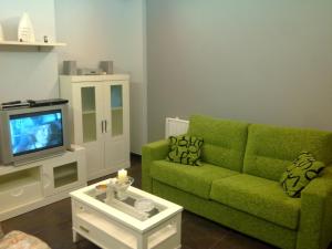 波多诺伏Residencial Parque los Laureles的客厅配有绿色沙发和电视