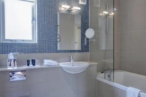 剑桥Quy Mill Hotel & Spa, Cambridge的一间带水槽、浴缸和镜子的浴室